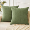 Solid olive green chenille throw pillow cover resting on a beige textured sofa cushion.