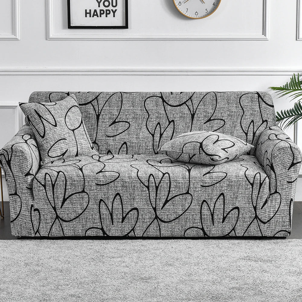 A gray floral print elastic sofa cover protector displayed on a light gray rug.