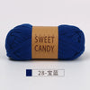 A skein of dark blue hand-dyed fabric strip yarn labeled Sweet Candy Yarns.