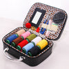 Portable sewing kit in a black box with an orange leopard print lining, containing various needles and threads.