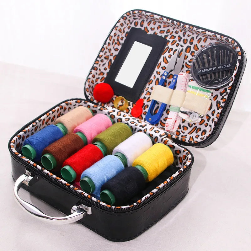 Portable sewing kit in a black box with an orange leopard print lining, containing various needles and threads.