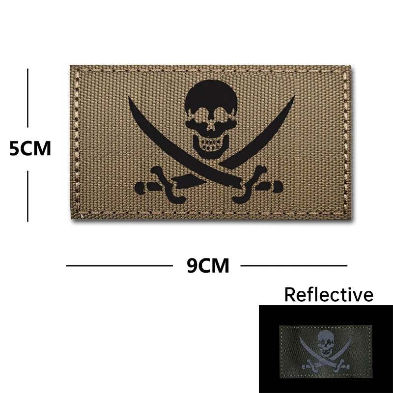 A brown embroidery patch featuring a black skull and crossed swords design on a tactical background.