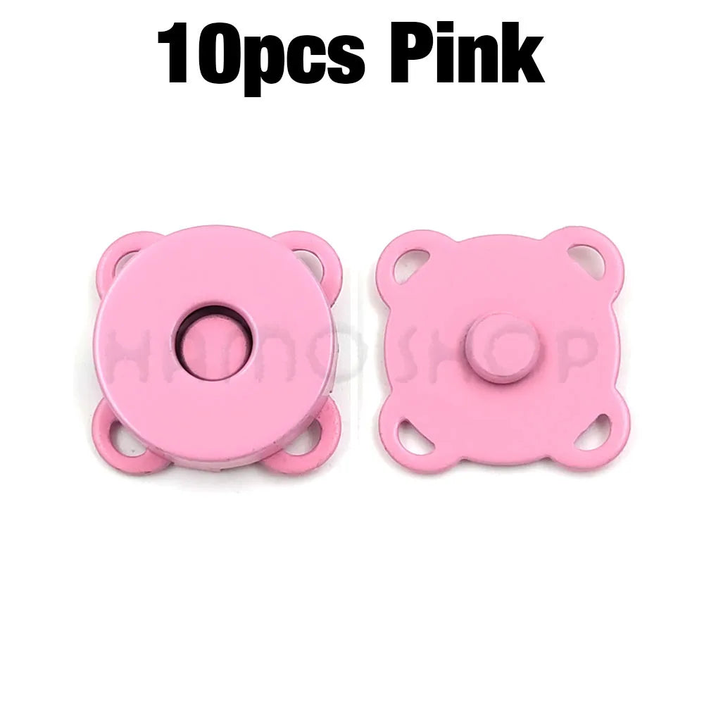 A pair of pink metal magnetic snap buttons for sewing.