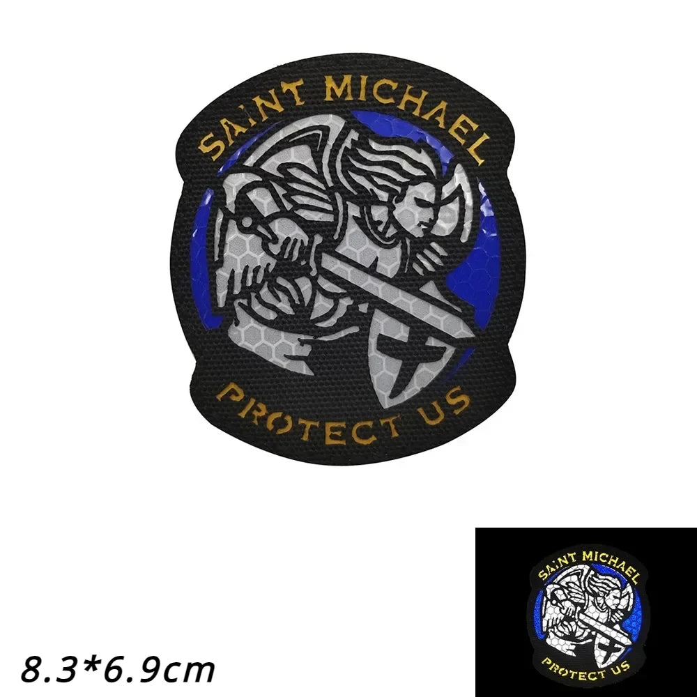 Black embroidered patch featuring Saint Michael with a sword and the text Protect Us