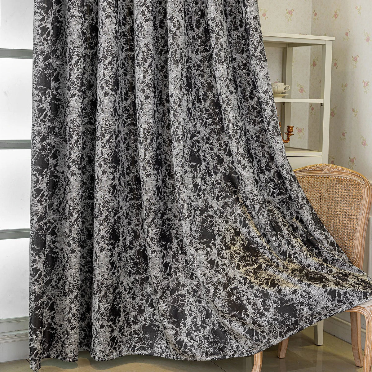 Blackout curtains featuring a tree bark pattern in black and white fabric hanging indoors.