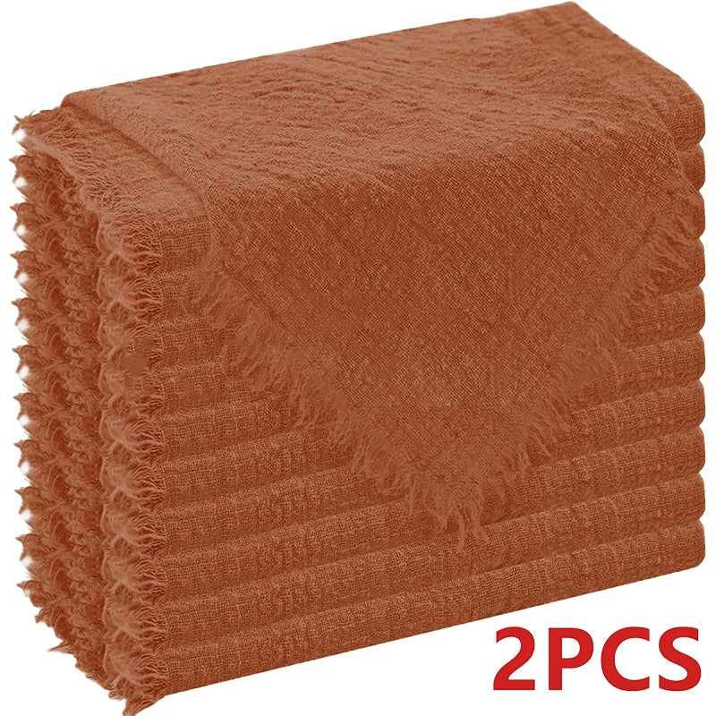 A stack of two rust-colored, textured cloth napkins.