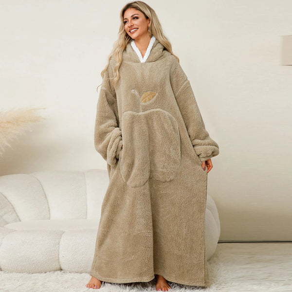 A woman models a oversized plush hooded blanket in beige color.