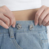 Close-up of hands fastening adjustable silver butterfly button clips onto denim fabric.