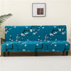 A teal sofa bed with a white floral branch pattern sits against a light wall.