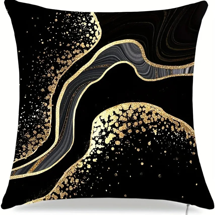 Black pillow cover featuring a swirling gold and black marbled pattern with scattered gold spots