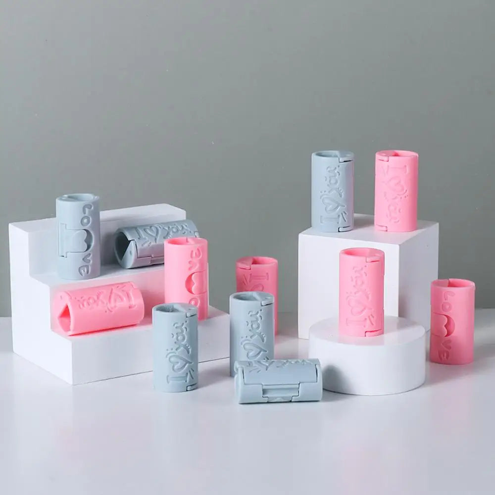 A collection of pink and light blue invisible sheet clips arranged on white display stands.