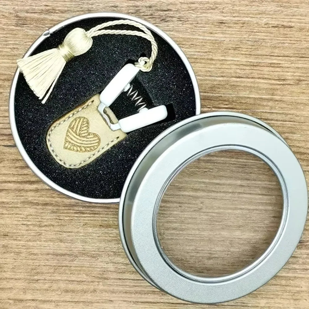 Mini precision sewing scissors with a protective cover and a silver ring.