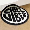 Black and white fuzzy round rug with the text SKILL VIBES in a bold font
