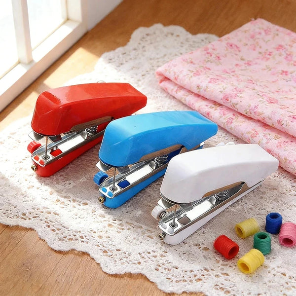 Three portable handheld sewing machines in red, blue, and white resting on a white lace fabric.