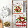 A set of two absorbent kitchen towels featuring strawberry and floral designs hanging on a wooden rack.