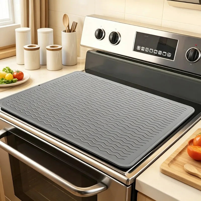 A heat-resistant silicone stove top cover mat is placed inside a modern stainless steel oven.