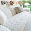 A white quilted sofa cushion cover with a beige trim and decorative fabric samples shown in a close-up view.