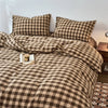 A plaid duvet cover set in brown and tan tones with a checkered pattern on a bed.