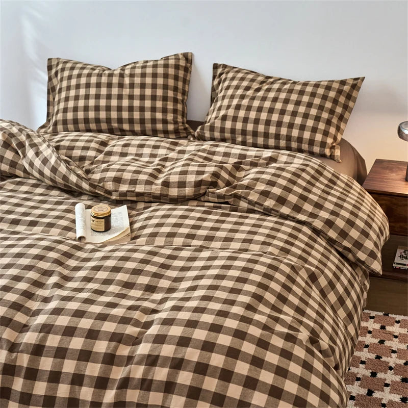 A plaid duvet cover set in brown and tan tones with a checkered pattern on a bed.