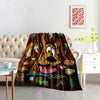 A playful cartoon dog flannel throw blanket draped over a sofa in a bright living room.