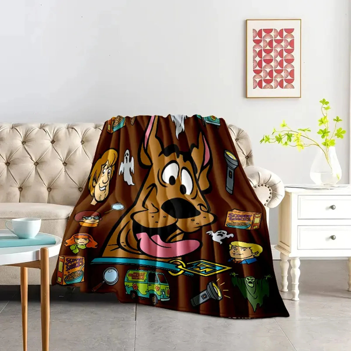 A playful cartoon dog flannel throw blanket draped over a sofa in a bright living room.