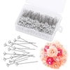 A clear plastic box filled with silver diamond pins and a set of rose-colored floral pins.