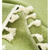 Close-up of cream colored cotton tassels attached to a green fabric, showing texture and stitching.