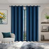 Navy blue blackout curtains hanging in a doorway, framing a view of greenery and an arched niche.