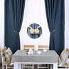 A table setting with a white tablecloth and dark blue curtains, featuring magnetic curtain tiebacks and decorative fabric.