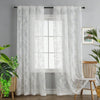 White vintage floral lace curtains hanging in a window with sheer white fabric.