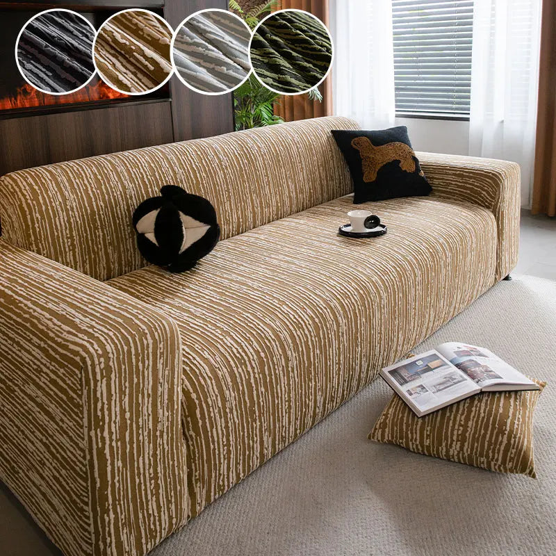 A beige jacquard plush elastic sofa cover with a textured pattern and decorative pillows on a light carpet.