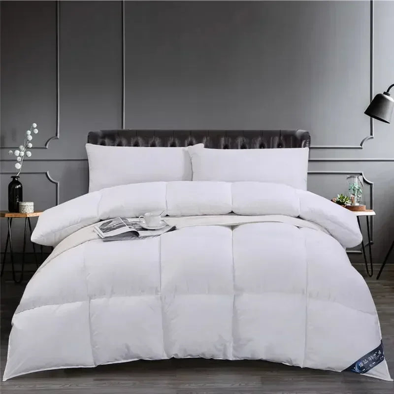 A white premium goose down comforter duvet is displayed on a bed with gray walls and modern lighting.