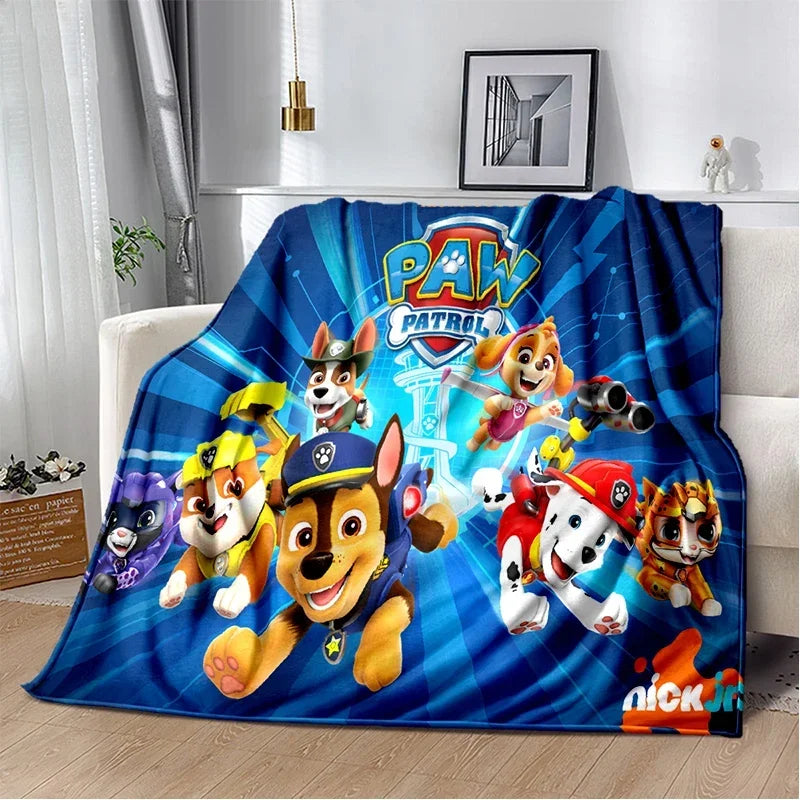 A blue and yellow Paw Patrol themed flannel throw blanket featuring cartoon dogs in action poses.