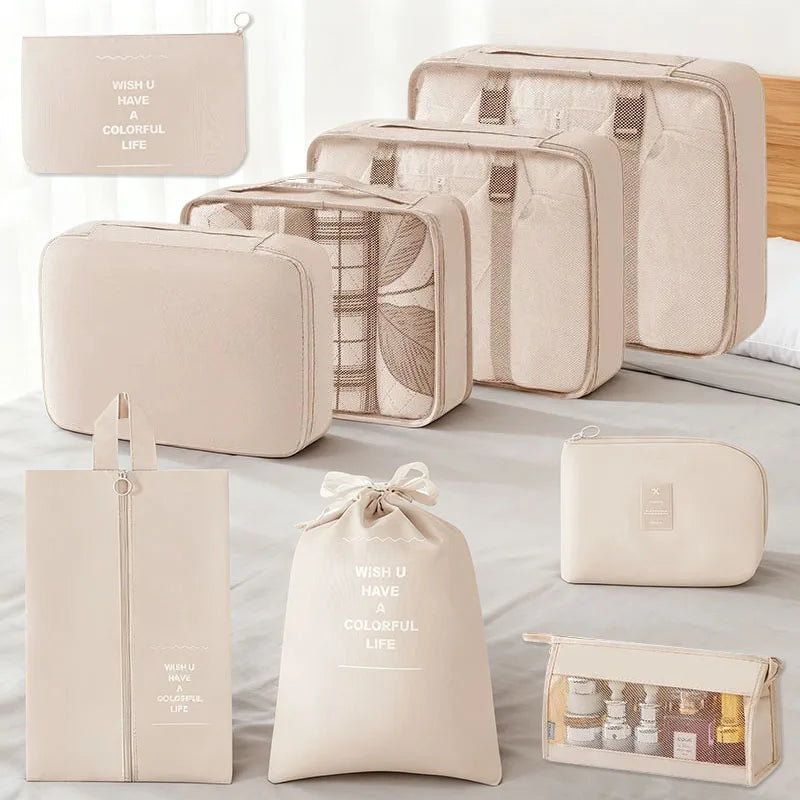 A set of beige and cream fabric travel storage organizers, including pouches and a box.