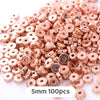 A pile of rose gold colored geometric acrylic beads for jewelry making