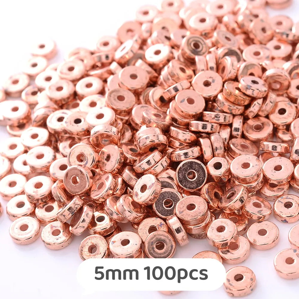 A pile of rose gold colored geometric acrylic beads for jewelry making