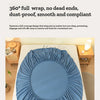 A rolled blue fitted sheet is displayed on a white bed, emphasizing its smooth and compliant design.