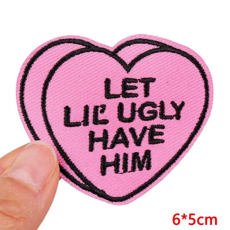 Pink heart shaped embroidered patch with black text that reads Let Lil Ugly Have Him