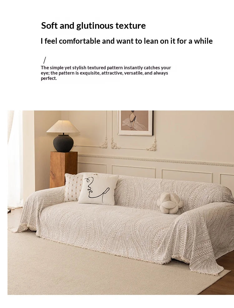 A beige herringbone chenille sofa cover draped elegantly on a light-colored sofa.