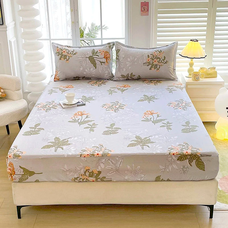 A fitted bed sheet with a floral print featuring soft greens and peach tones is displayed on a bed.