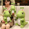 A woman is holding four soft green dinosaur plush toys of varying sizes on a light-colored sofa.