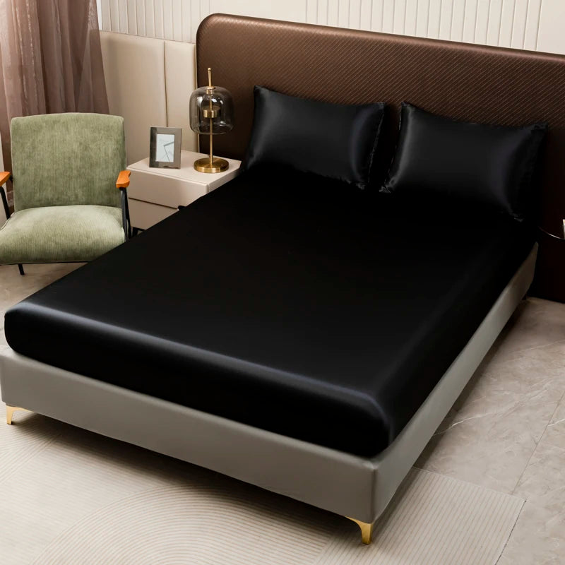 A modern bedroom featuring a bed with black satin bedding and brown upholstered headboard.