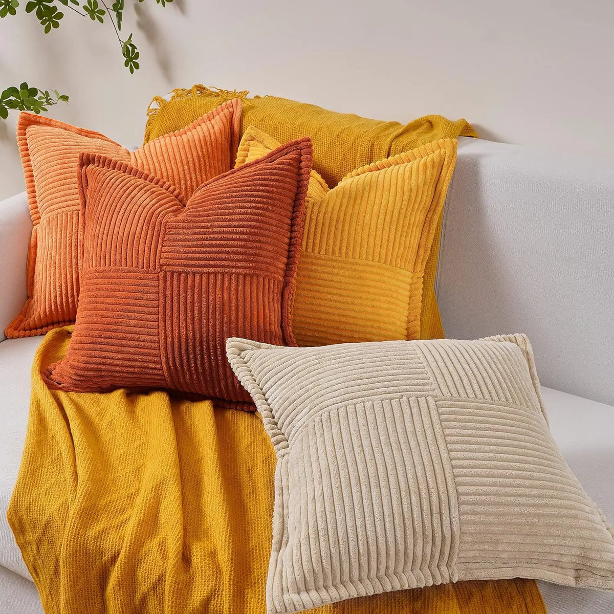 A collection of textured corduroy lumbar support pillows in shades of orange, yellow, and beige.