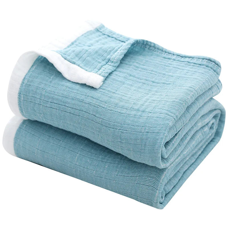 Light blue breathable 4-layer muslin throw blanket folded and rolled