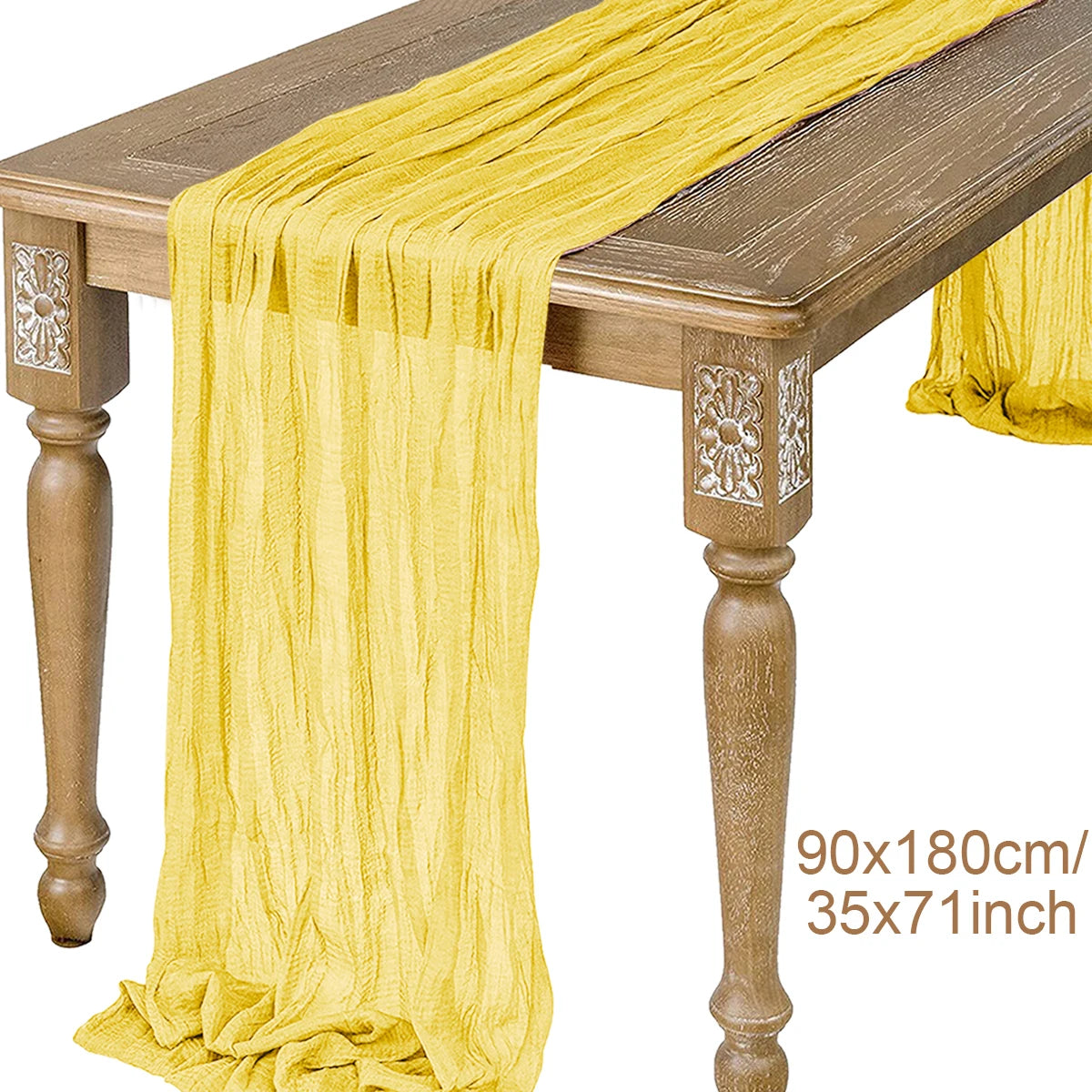A yellow semi-sheer gauze table runner draped over a wooden table.