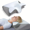 A white memory foam cervical neck pillow is shown being used for sleep or massage.