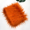 A fluffy orange faux fur fabric used for sewing and crafting.