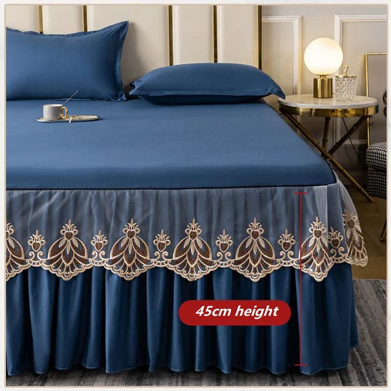 A navy blue embroidered cotton bedspread and pillow set displayed on a bed.