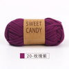 A skein of sweet candy purple hand-dyed yarn labeled Sweet Candy Yarns.