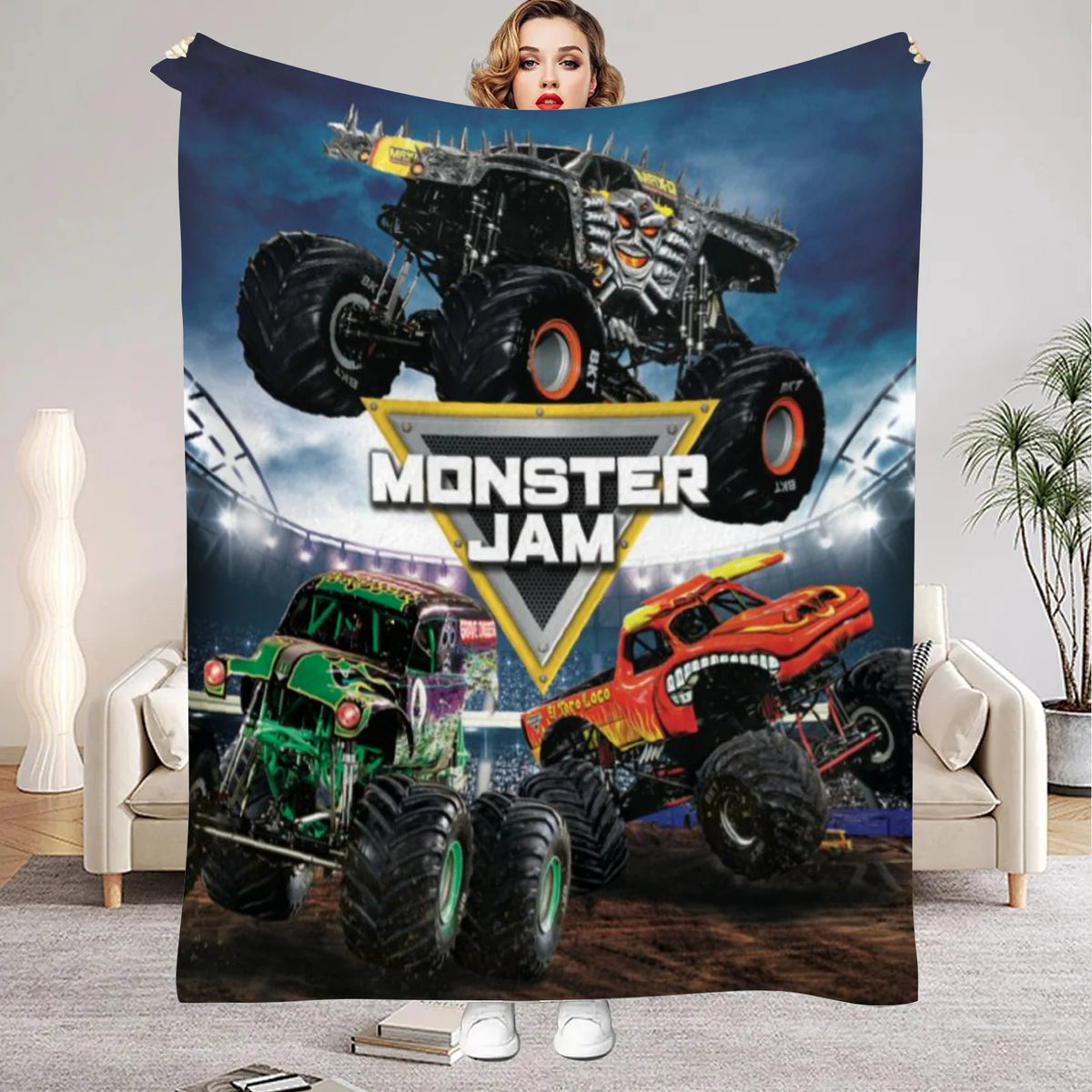 A Monster Jam flannel throw blanket featuring images of monster trucks and a large monster truck.